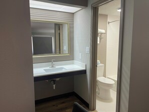 A bathroom with a sink, mirror, and toilet. - Red Roof Inn Helen, GA - Downtown (Helen)