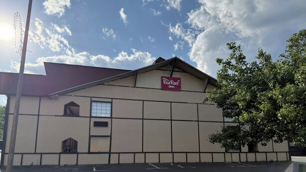 Edificio de Red Roof Inn con techo plano, un ventanal grande y un letrero lateral.