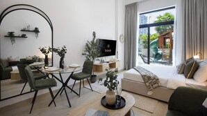 Ein modernes Wohnzimmer mit einer Couch, einem Esstisch, Stühlen, einem Fernseher und einem Balkon mit einer Rutsche.