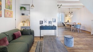 Un soggiorno moderno con un divano verde, un tavolino da caffè e un'area da pranzo con tavolo e sedie.