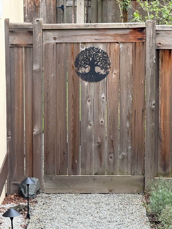 A wooden gate with a tree-shaped metal decoration.