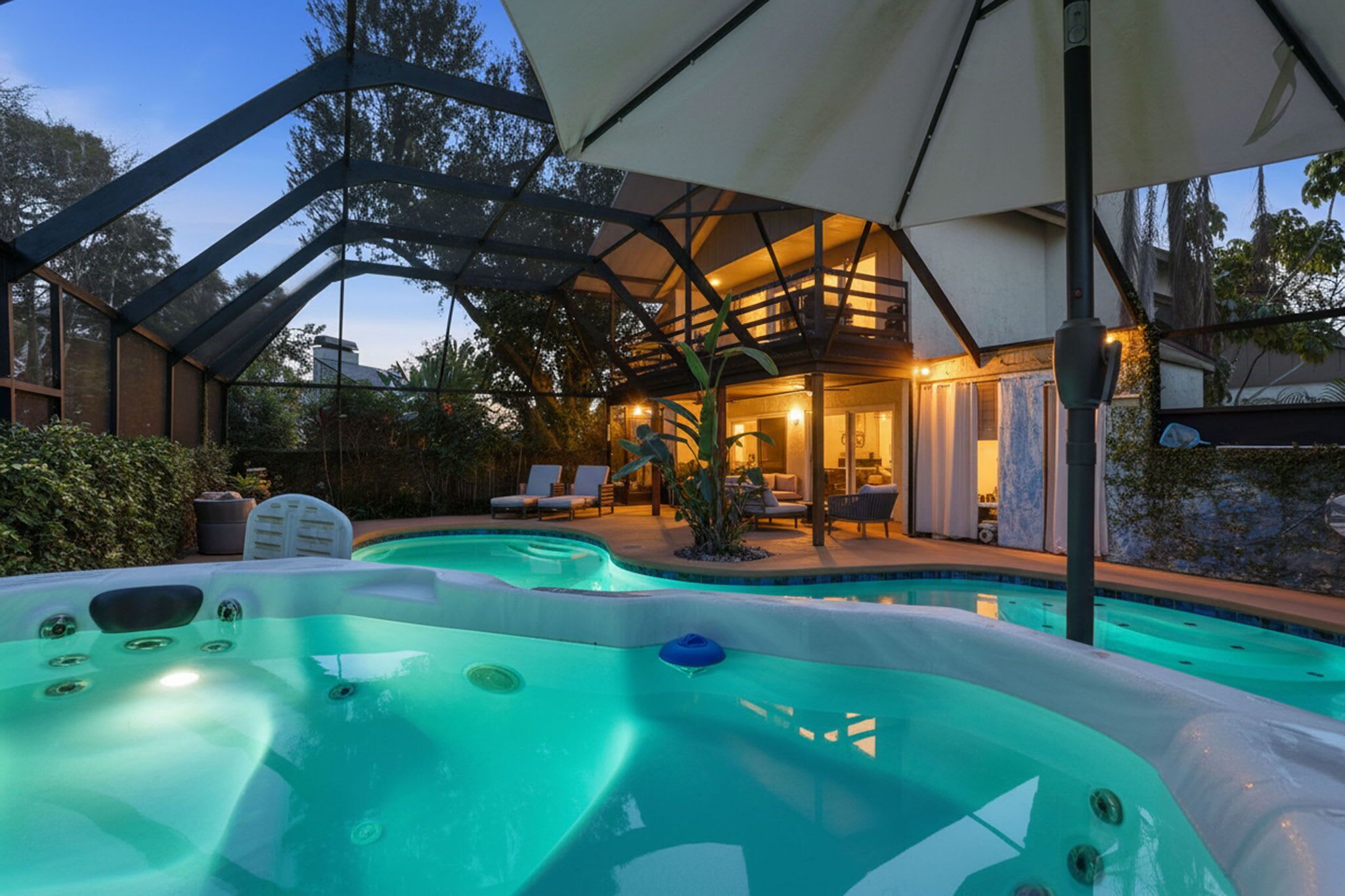 Una piscina con jacuzzis, un patio cubierto y un espacio interior bien iluminado.