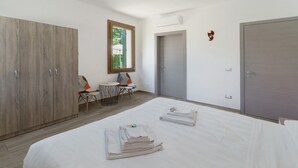 A bedroom with a bed, a wardrobe, a small table with chairs, and a window. - Apartment with 3 Beds (Mira)