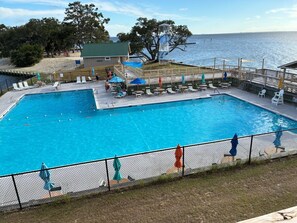 Ein Pool mit Sonnendeck, Liegestühlen und Sonnenschirmen.