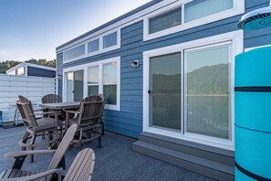 A blue house with a patio, a table, and chairs.