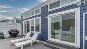 Un bâtiment moderne doté d’un patio couvert, d’un espace extérieur aménagé pour s’asseoir et de grandes fenêtres.