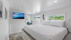 A bedroom with a large bed, a TV, a window with a view, and a 'RELAX' sign. - Four Suns - Lake Front Floating House Retreat (Russell Springs)