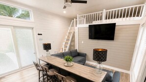 A modern kitchen with a dining area, a staircase, and a TV mounted on the wall. - Pet-Friendly Floating House on the Lake (Russell Springs)