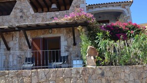 A stone building with a balcony, a stone wall, and a bell tower. - Ftam-corn01 in Tamarispa (Budoni)