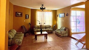 A spacious living room with a sofa set, a coffee table, and a chandelier.