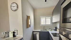 A compact kitchen with a washing machine, dishwasher, and a built-in oven. - Detached, newly refurbished, 3 bed house with parking, 2 min walk from the beach (Fuengirola)