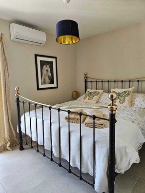 A bed with a black metal frame, white bedding, and decorative pillows. - Detached, newly refurbished, 3 bed house with parking, 2 min walk from the beach (Fuengirola)