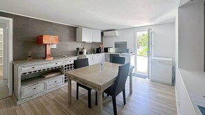 Eine moderne Küche mit Essbereich, integrierten Geräten und Blick ins Freie.