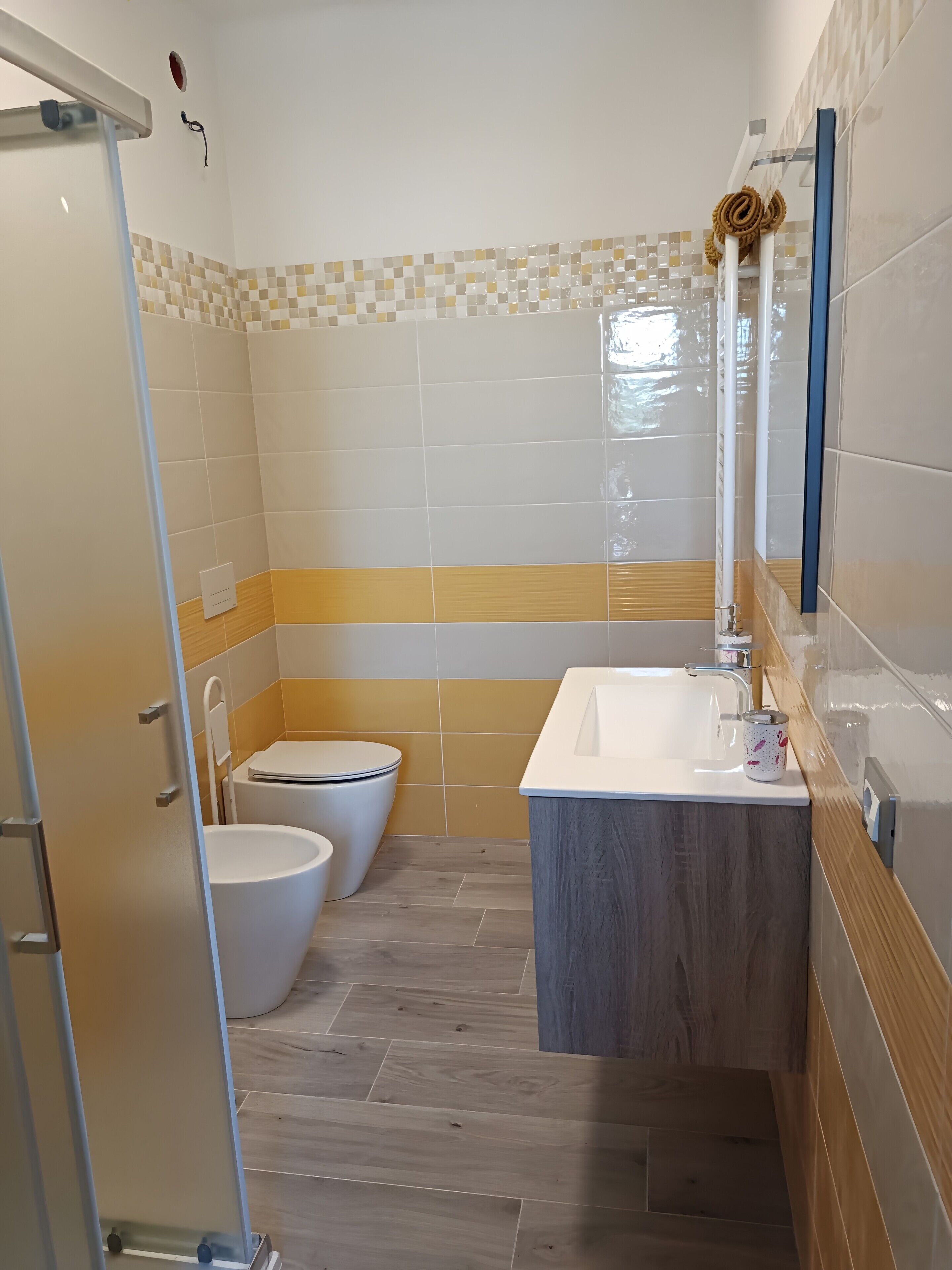 Un baño con inodoro, lavamanos y zona de ducha.