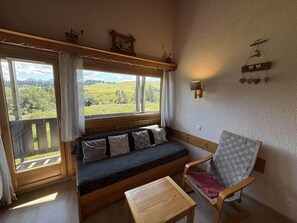 Ein gemütliches Zimmer mit einer hölzernen Bank, einer gepolsterten Sitzgelegenheit und einem kleinen Tisch.