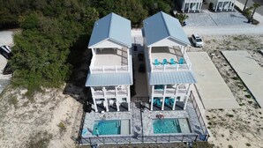 Propiedad frente al mar de dos pisos con piscina y mobiliario exterior.