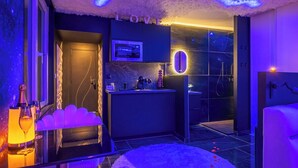 A modern bathroom with a vanity, mirror, and shower area. - L'Etage des nuages - Jacuzzi & precious moments (La Flèche)