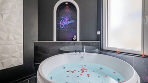 A modern bathroom with a large bathtub, a galaxy-themed mirror, and a neon sign. - L'Etage des nuages - Jacuzzi & precious moments (La Flèche)