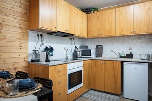A compact kitchen with wooden cabinets, a microwave, a toaster, and a dishwasher.