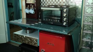 Una cocina con un refrigerador rojo, un microondas y una estufa.