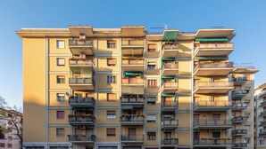 A multi-story residential building with balconies, a bicycle, and parked cars. - Home OF Mestre (Venezia)