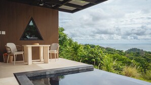 A modern outdoor seating area with a pool, wooden paneling, and a view of a lush landscape. - Modern adults-only villa with private plunge pool and panoramic ocean-to-mountain views. (Manuel Antonio)