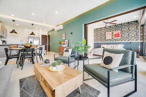 A modern living room with a sofa, coffee table, and dining area. - Zona Romantica Condo | Rooftop Pool | 1 Min Beach (Puerto Vallarta)
