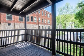Eine Holzterrasse mit einem Ziegelgebäude im Hintergrund.