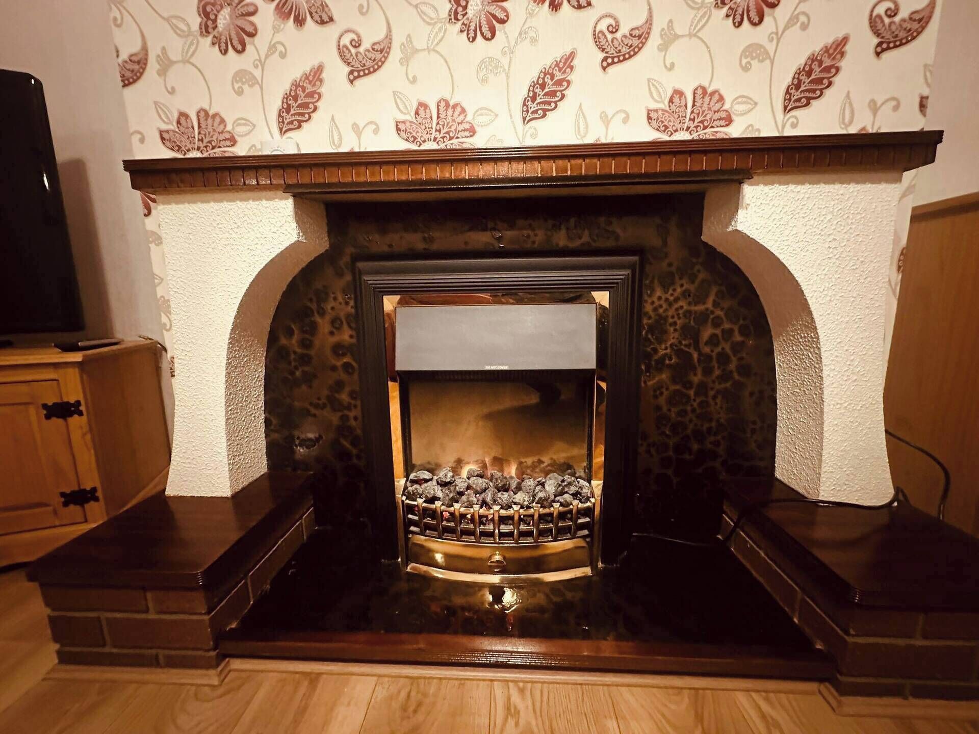 A fireplace with a stone surround and a decorative mantel.