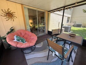 A patio with a cushioned chair, a table, and chairs. - Rocket Retreat - NASA & Orlando (Titusville)