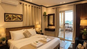 A modern hotel room with a large bed, bedside tables, a desk, and a view of the outdoors. - Foola Pyramids Inn Hotel (Giza)
