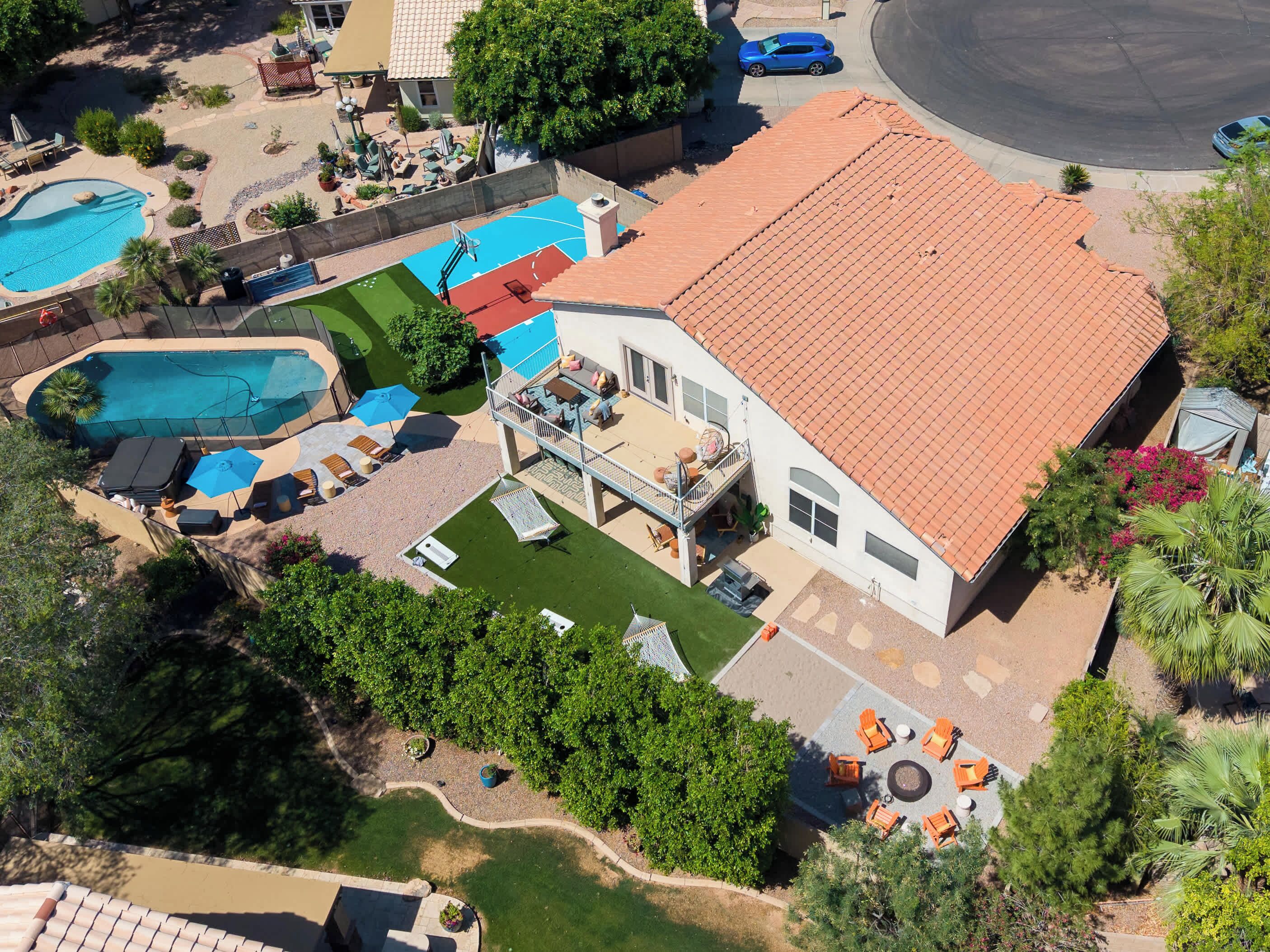 A residential property with a swimming pool, patio furniture, and a covered outdoor seating area.