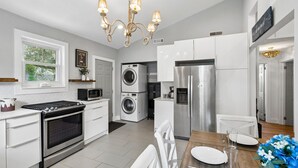 Eine moderne Küche mit Herd, Backofen, Mikrowelle, Waschmaschine und Kühlschrank.
