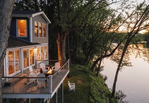 A house with a deck, outdoor seating, and a fire pit.