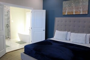 A bedroom with a bed, a door leading to a bathroom, and a wall-mounted artwork. - New -Atlanta Gem-Close to Mercedes-Benz (World Cup), World Congress Center & State Farm (Atlanta)