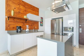 Eine moderne Küche mit einer Wand in Holzoptik, Edelstahlgeräten und einer integrierten Kochinsel.