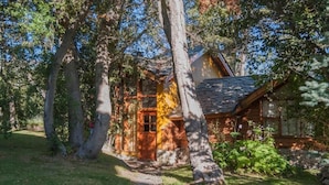 A rustic cabin surrounded by trees, with a clear path leading to the entrance. - Lelikelen Cabañas del Bosque (Villa La Angostura)