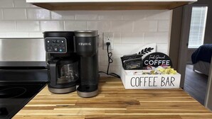 Une cuisine équipée d’une machine à café Keurig, d’une autre machine à café et d’un espace dédié à la préparation du café.
