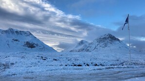 A snowy mountain landscape with a flagpole.