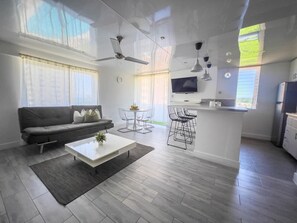 En moderne stue med sofa, sofabord og spiseplads.