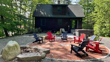 Une cabane avec un foyer, des sièges d’extérieur et un brasero en pierre.