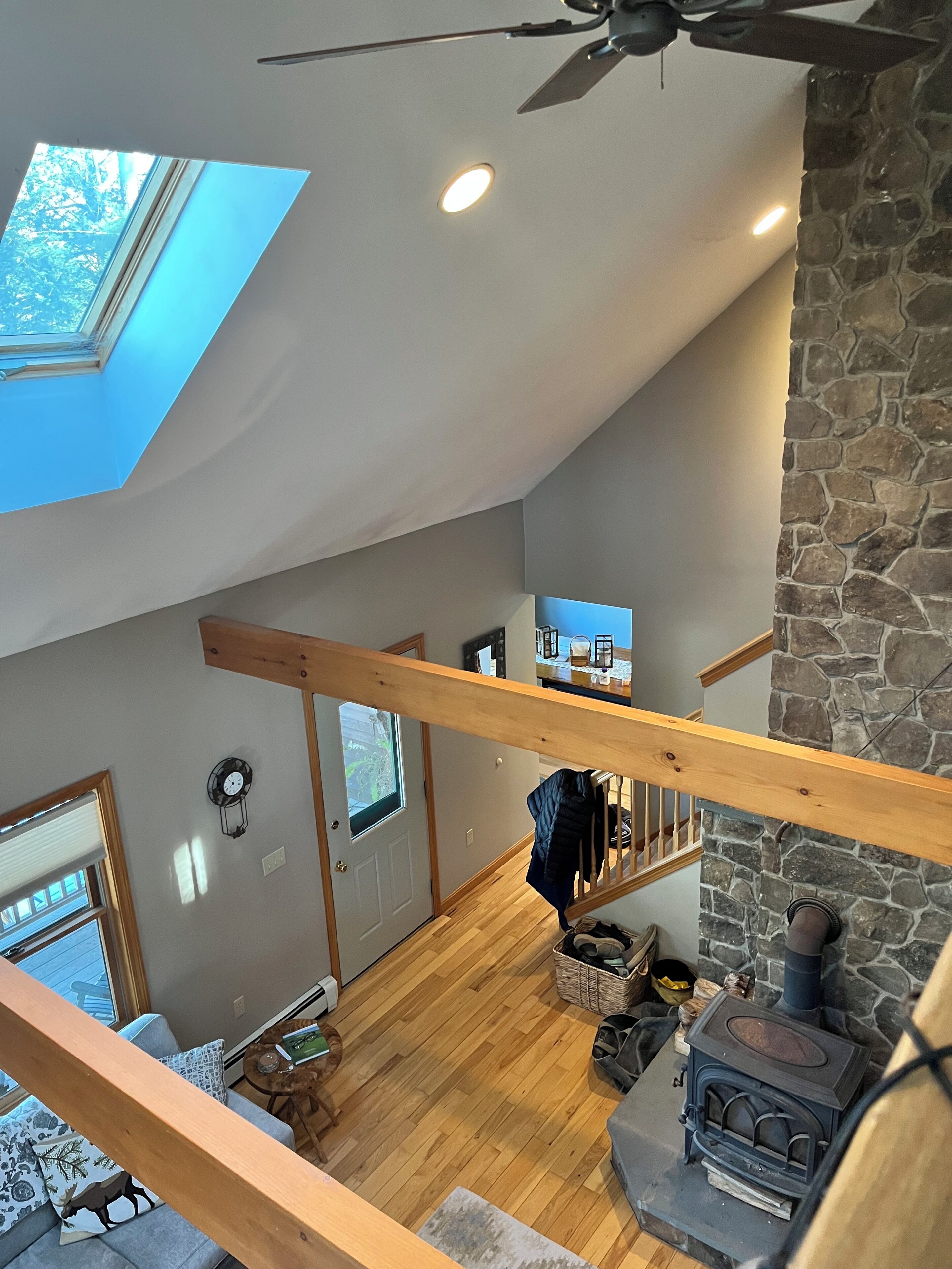 Une pièce de style « loft », dotée d’une lucarne, d’une cheminée en pierre et d’un escalier en bois.