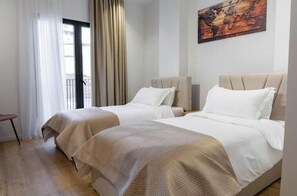 A hotel room with two beds, a view of the outside, and a world map on the wall. - Barrikada-E – Central Apartments with French Balcony in Tirana (Tiranë)