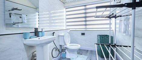 Un baño moderno con lavamanos, inodoro y toallero.
