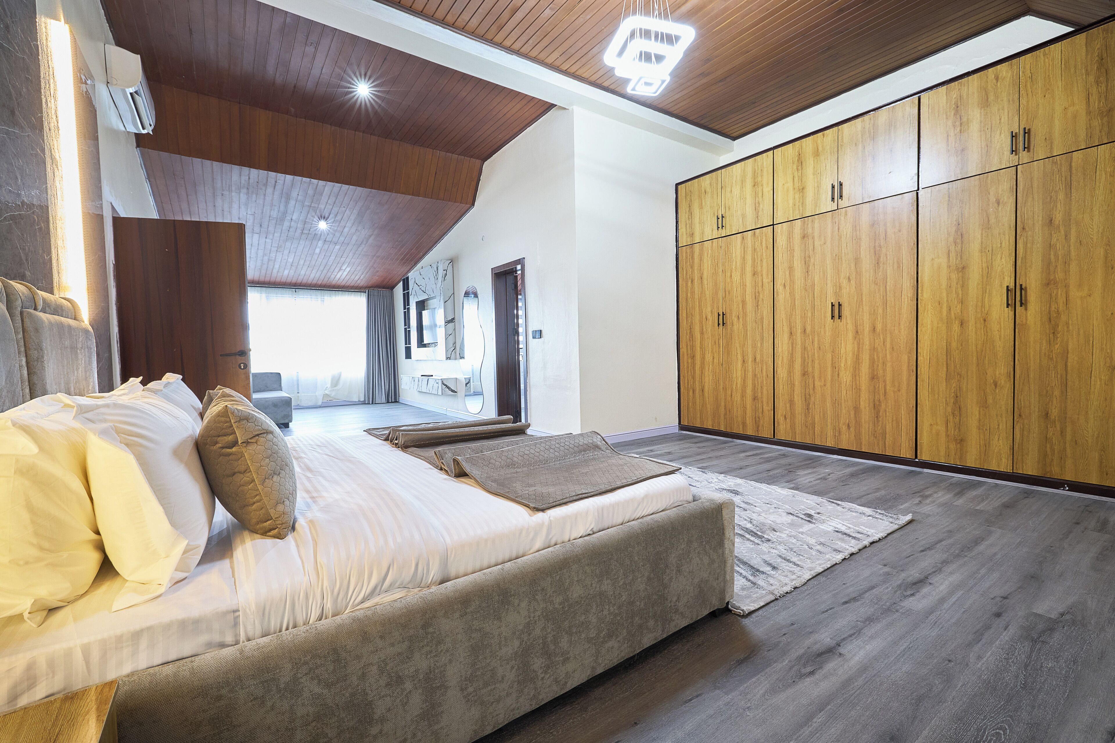 Una camera da letto con un letto, un armadio in legno e vista all'esterno.