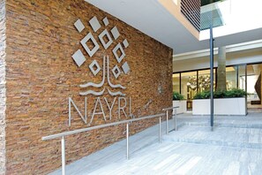 A brick wall with the text 'NAYRI' and a modern building entrance. - Zona Romantica Condo | 1 Min Beach | Rooftop Pool, Gym & Spa (Puerto Vallarta)
