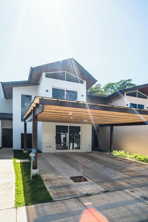 A modern two-story house with a covered patio, a driveway, and a mailbox. - Summer House Azul - Private swimming pool - 3 rooms (Jacó)