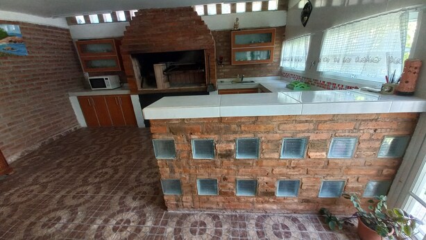 Una cucina con camino in mattoni, pavimento piastrellato e finestra vista.