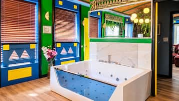 Ein modernes Badezimmer mit freistehender Badewanne, grünen und blauen Wänden sowie einer Holzbalkendecke.