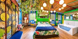 Una habitación con cama, mesitas de noche, un escritorio y un espejo.